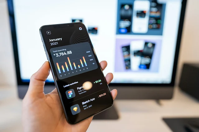 スマホの筋トレ記録アプリで総負荷量のグラフを確認し、成長を実感している30代男性